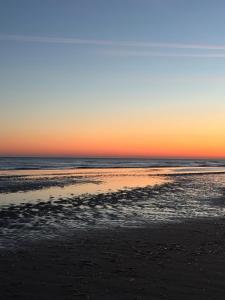 a beach at sunset with the ocean in the background at Secret Stay, Wellness Penthouse studio, Privacy, Seaview, Terras, Sauna in Koksijde