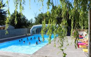 a group of people swimming in a swimming pool at Camping Le Neptune in Lanloup
