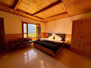 a bedroom with a large bed and a wooden ceiling at Misfits Hostel and Cafe in Shoja