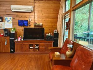 a living room with a television on a wooden wall at Beauty House in Nanzhuang