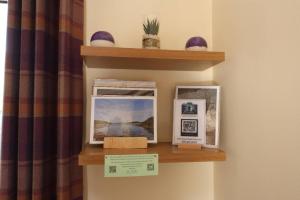 a shelf with pictures on it next to a curtain at Number 4, Loch Shiel View in Glenfinnan