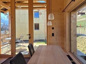 a dining room with a table and chairs and a large window at Ferienhäuser Stiva Pintga in Somvix +30 photos