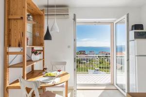 a kitchen with a table and a view of the ocean at Holiday home with several apartments, a pool, sea views and a barbecue near Split in Podstrana