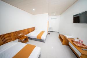 a room with two beds and a flat screen tv at Kahyuna Hotel Bromo in Sukapura