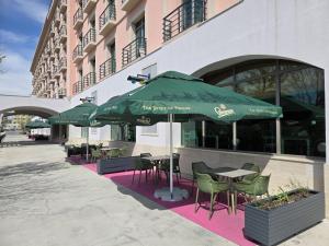 a restaurant with tables and chairs and umbrellas at Phoenicia Express Hotel in Bucharest