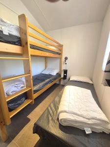 a room with two bunk beds in a room at The Mobil home Confort Clim / 2 Chb / 5 Pers in Lagorce +8 photos