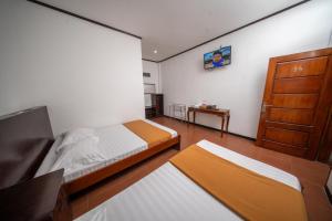 a bedroom with two beds and a wooden door at Kahyuna Hotel Bromo in Sukapura