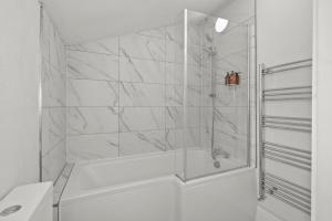 a white bathroom with a shower with a tub at 5-Bed Family & Group Stay Near Cricket Ground in Worcester +108 photos