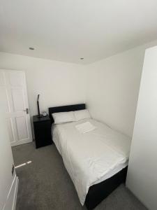 a white bedroom with a bed and a white wall at Tilbury Docks Rooms for Short letting in Tilbury