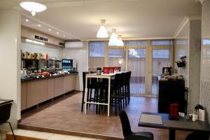 a kitchen with a counter and a table and chairs at Triple M Hotel in Budapest