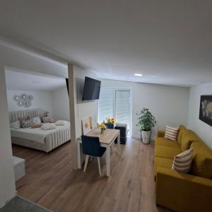 a living room with a yellow couch and a table at Apartments Emilija in Brela