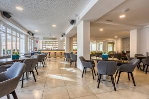 a dining room with tables and chairs and windows at Morlans Garden in Paguera