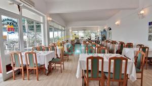 ein Esszimmer mit weißen Tischen und Stühlen und Fenstern in der Unterkunft Hotel Cerna in Saturn + 61 Fotos