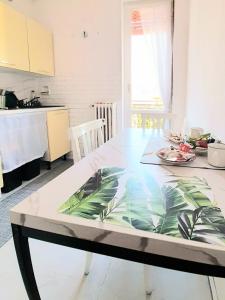 a dining room table with a leaf table cloth on it at Luino Flowers Home in Luino +14 photos