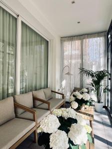 a living room with couches and flowers on a table at Hotel Ferrara in Cattolica +16 photos
