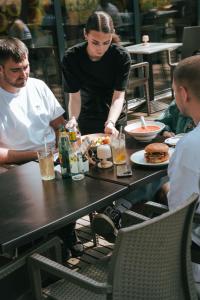 Eine Frau isst an einem Tisch in einem Restaurant. in der Unterkunft Chill Camp in Giewartów