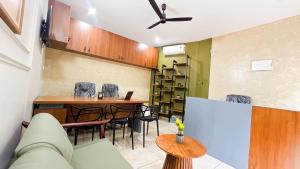 a living room with a couch and a table at SafeStay Wayanad - 1BHK & 2BHK with Kitchen Facilities in Wayanad