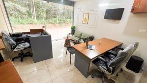 an office with a desk and chairs in a room at SafeStay Wayanad - 1BHK & 2BHK with Kitchen Facilities in Wayanad