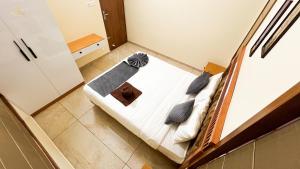 a bedroom with a bed with white sheets and blue pillows at SafeStay Wayanad - 1BHK & 2BHK with Kitchen Facilities in Wayanad