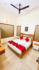 a bedroom with a large bed with red pillows at SafeStay Wayanad - 1BHK & 2BHK with Kitchen Facilities in Wayanad