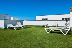 three lounge chairs and a table on a lawn at Casa Vista Mar Oliastur El Cotillo in El Cotillo