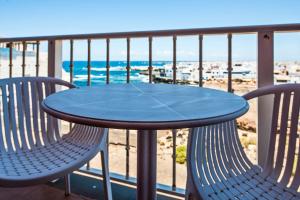 a table and two chairs on a balcony with the beach at Casa Vista Mar Oliastur El Cotillo in El Cotillo