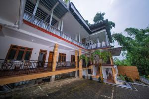 a white house with a balcony and a courtyard at Kahyuna Hotel Bromo in Sukapura