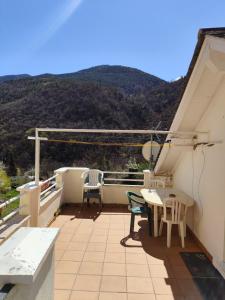 a balcony with a table and chairs and a mountain at Studio décor chalet jusqu'à 6 couchages in Fontpédrouse +4 photos