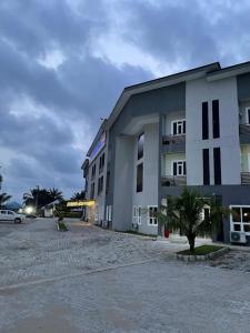 a white building with a palm tree in front of it at Pearl Paradise Resort by 4E in Finima