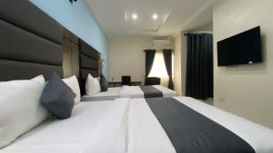 a hotel room with two beds and a flat screen tv at Pearl Paradise Resort by 4E in Finima +67 photos