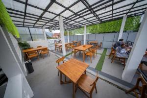 an outdoor patio with wooden tables and chairs at Kahyuna Hotel Bromo in Sukapura +66 photos