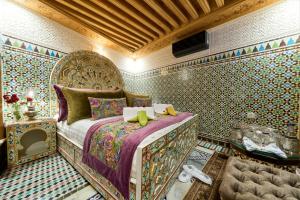a bedroom with a bed in a room with wallpaper at Riad May Fes Original & Spa in Fez +41 photos