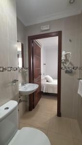 a bathroom with a sink and a toilet and a sink at Hostal Victoria Mar in Chipiona
