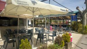 a restaurant with tables and chairs and an umbrella at Camping Ezcaba in Maquirriain