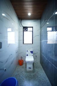 a bathroom with a toilet and a window at sinhgad hills in Kharakvasla