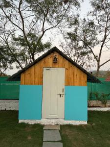 a small wooden building with a white door at sinhgad hills in Kharakvasla