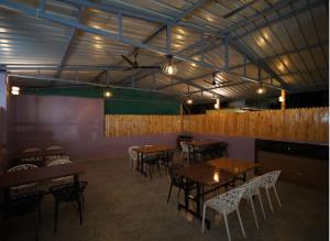 a restaurant with wooden tables and chairs and lights at sinhgad hills in Kharakvasla