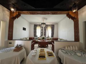 a room with two tables and a living room at Domaine Ghait in Had Abdallah Rhiat