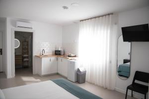 a white room with a bed and a kitchen at M&A Hostal en Onda in Bechí