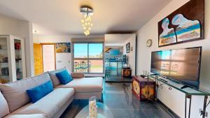 a living room with a couch and a flat screen tv at Beach Apartment Marfolin 06 El Cotillo in El Cotillo