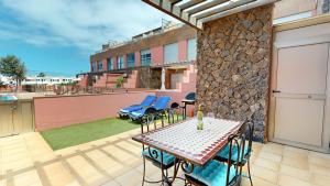 a patio with a table and chairs on a balcony at Beach Apartment Marfolin 06 El Cotillo in El Cotillo