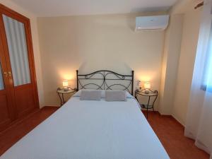 a bedroom with a large bed with two lamps on it at Pensión Dani in Casinos