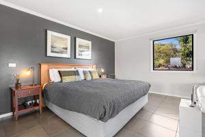 a bedroom with a large bed and a window at Blaze Rock Retreat in Halls Gap