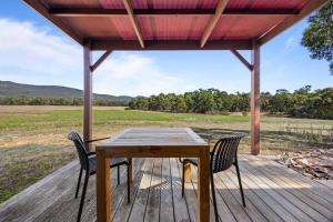 a wooden table and chairs on a wooden deck at Blaze Rock Retreat in Halls Gap +23 photos
