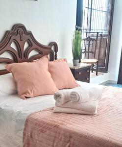 a bed with two folded towels on top of it at Casa cubo in Alhama de Granada +66 photos