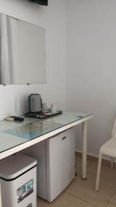 a white counter with a table and a chair at Hostal Victoria Mar in Chipiona