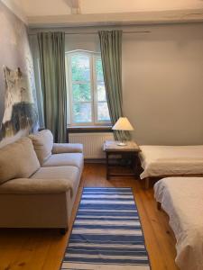 a living room with a couch and a window at Pałacyk Trzcińsko in Trzcińsko