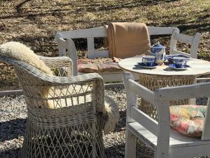 two wicker chairs and a table and a table and chairs at Pałacyk Trzcińsko in Trzcińsko