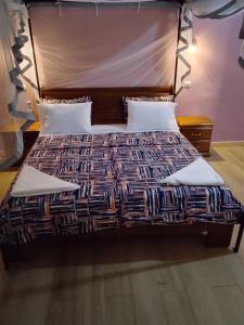 a bed with a wooden headboard in a bedroom at la villa du parc in Niaga