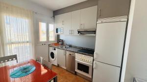 a kitchen with a white refrigerator and a table at Casa Mika Oliastur 25 El Cotillo in El Cotillo